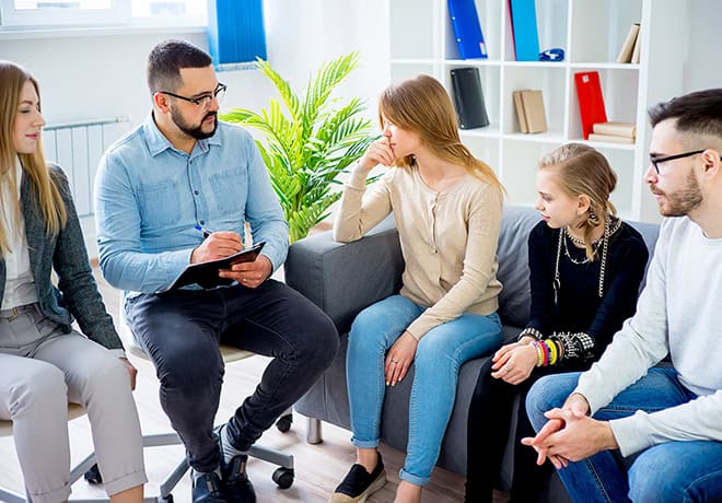 Four family members listening to a counselor