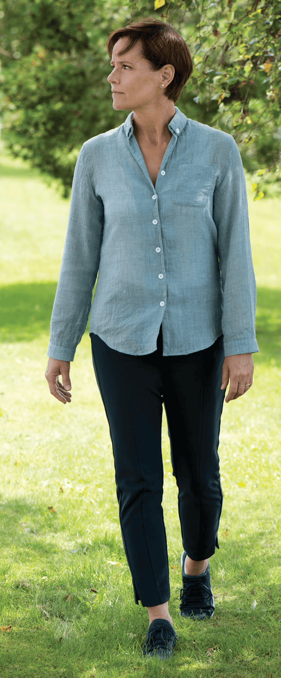 Woman looking afar walking through a park