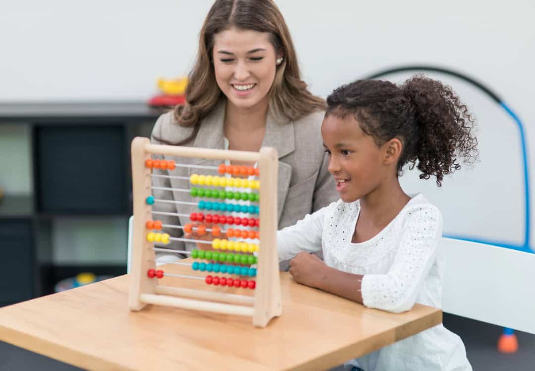 Child using abacus with adult supervision